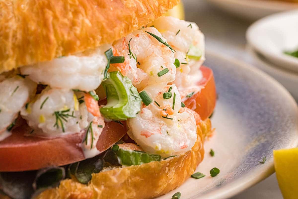 close up of lemon garlic shrimp salad on a croissant