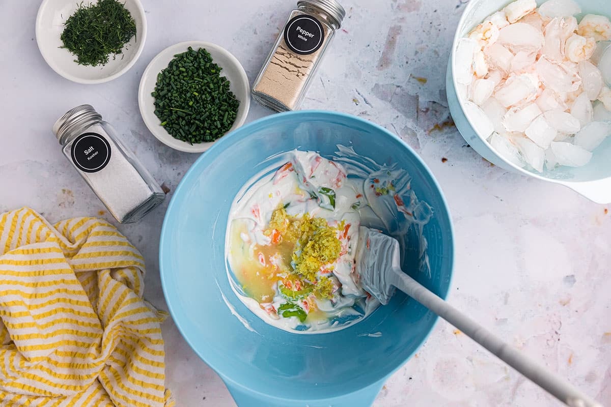 lemon juice and zest added to yogurt and veggies in bowl