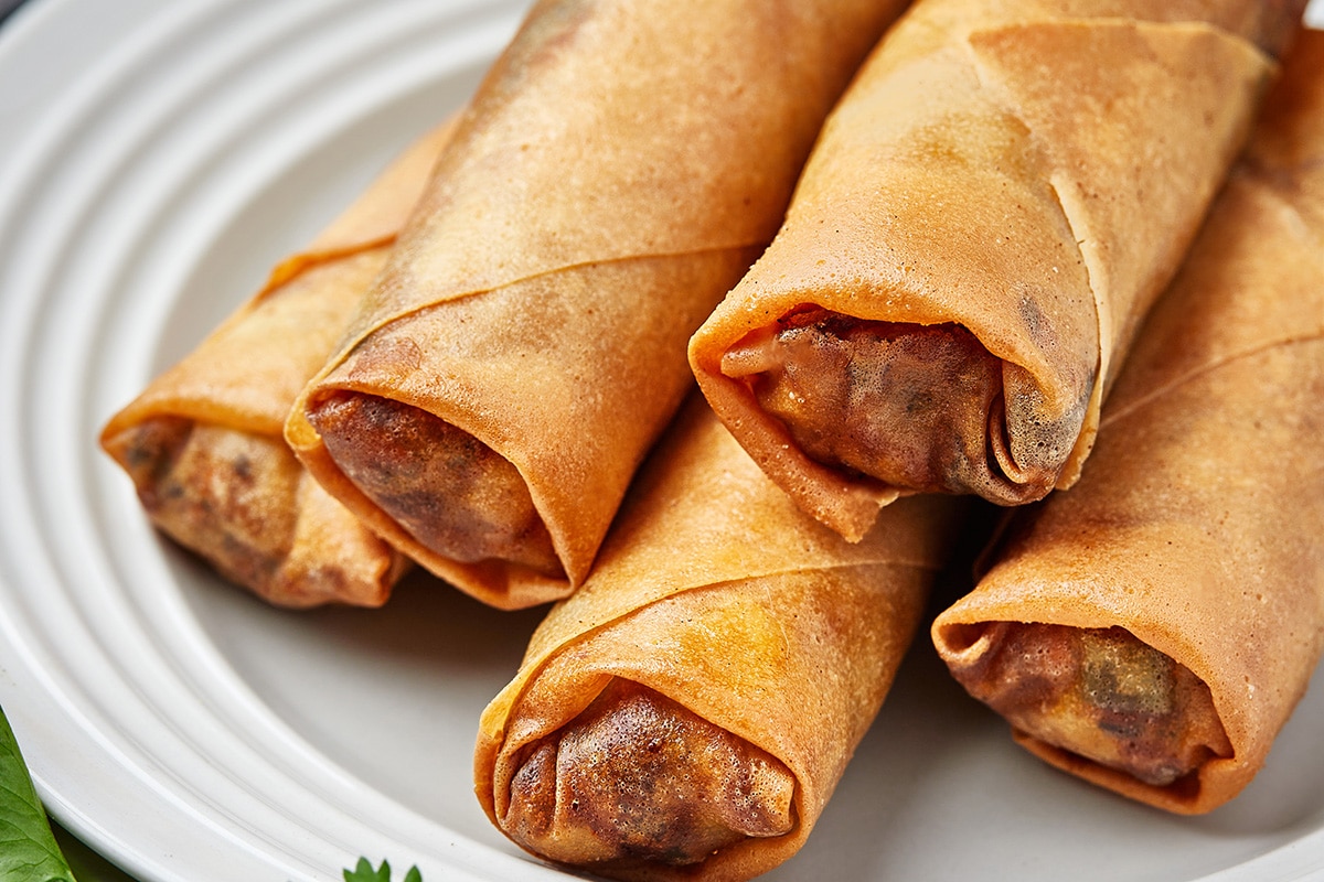 close up of stack of spring rolls on a plate