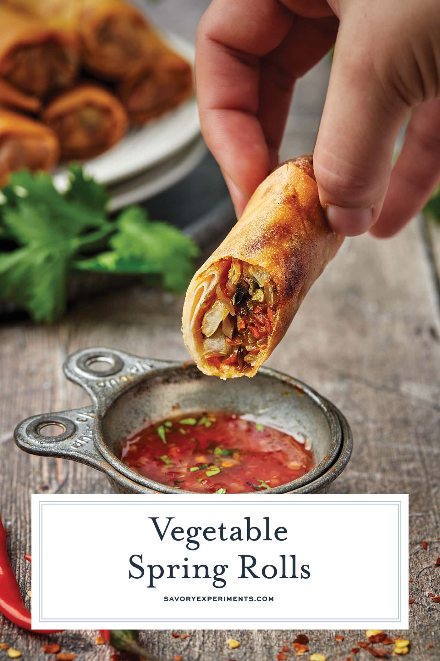 hand dipping spring roll into sauce with text overlay for pinterest