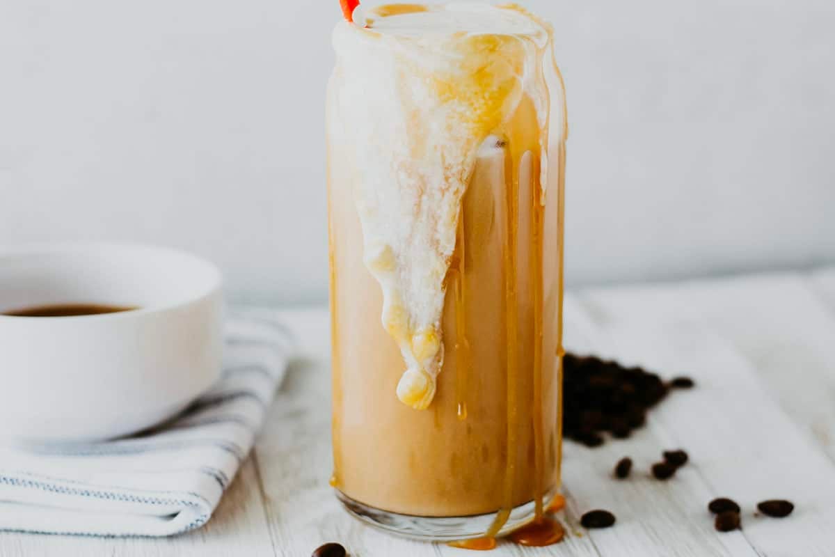 close up of cold foam and caramel drizzling out of a glass