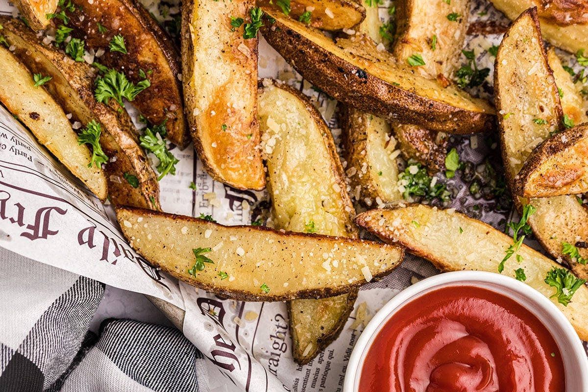 close up of parmesan truffle fries on a baking sheet with ketchup