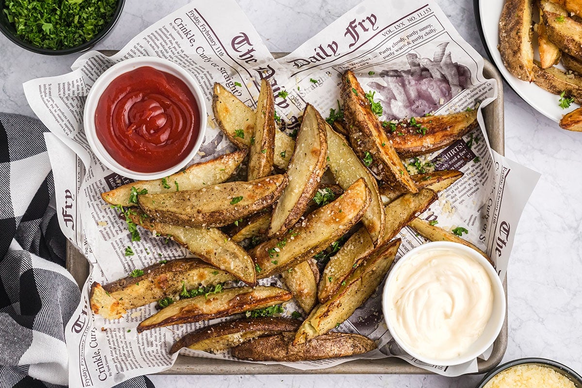 zoomed out overhead shot of truffle fries on a plate with dipping sauces