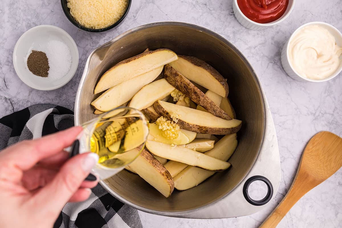 garlic and olive oil added to raw potato wedges