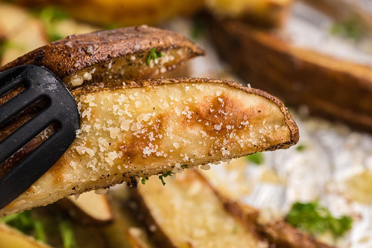 close up of tongs holding one truffle fry