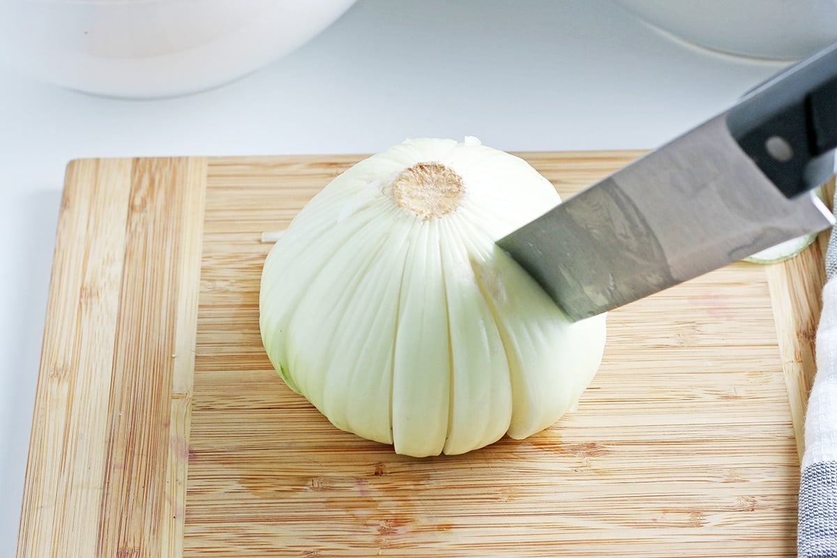 knife slicing onion into strips