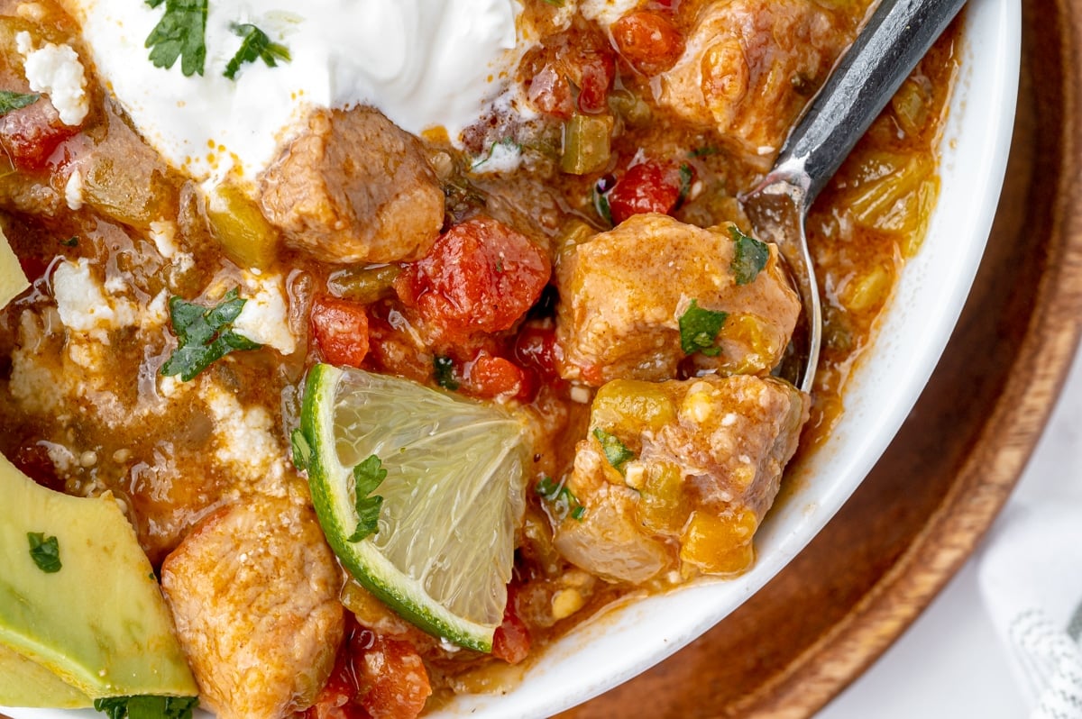 close up overhead shot of spoon in bowl of chili verde