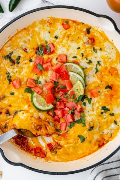 overhead shot of spoon in skillet of chorizo queso fundido