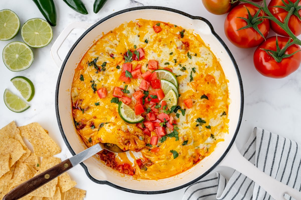 overhead shot of spoon in skillet of chorizo queso fundido