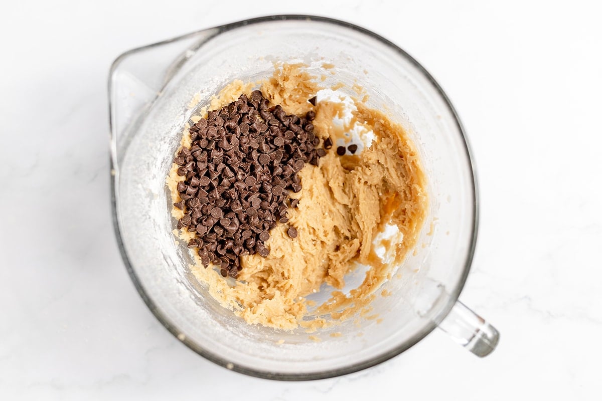 chocolate chips added to cookie dough in bowl