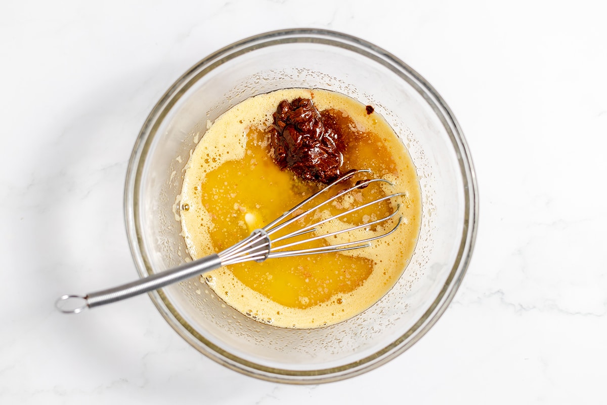 melted butter and chocolate in bowl with whisk