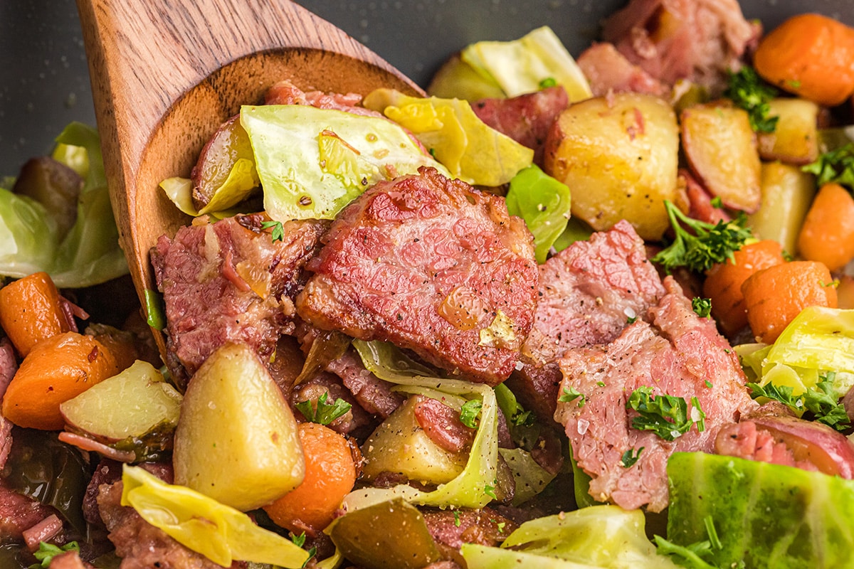 close up of corned beef and cabbage on wooden spoon