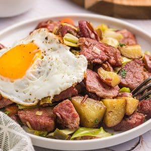 close up angled shot of corned beef hash with egg