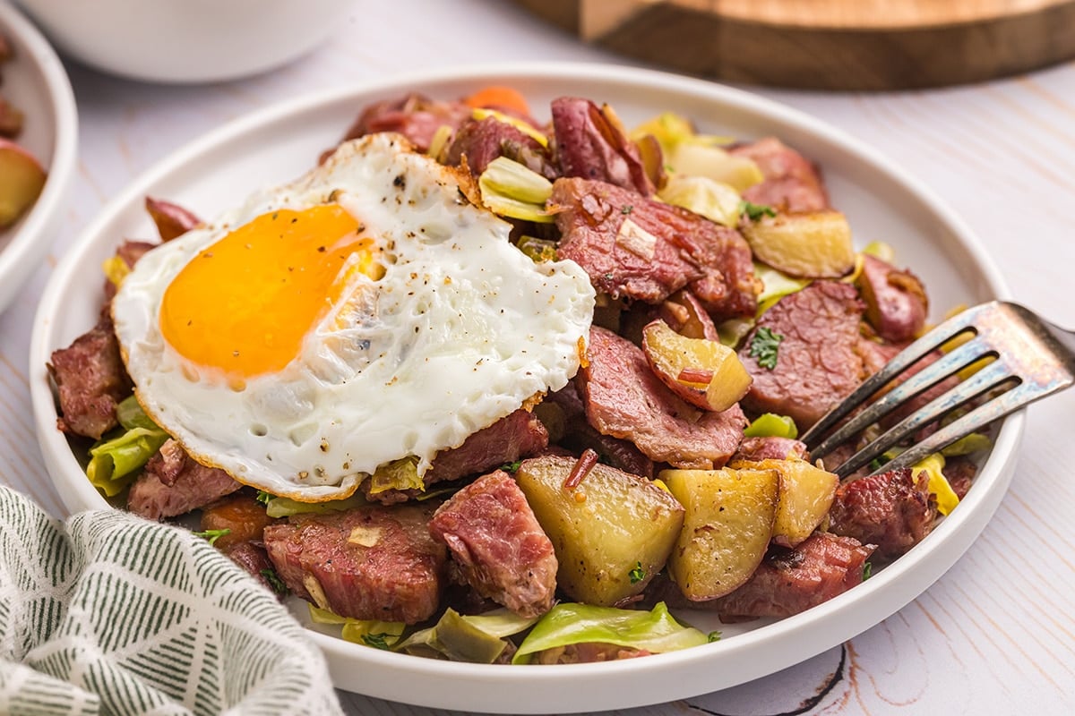 close up angled shot of corned beef hash with egg