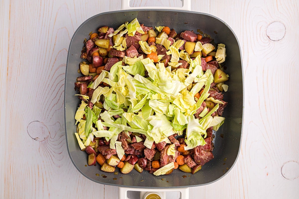 cabbage added to corned beef in pan
