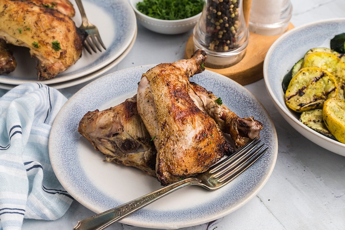 two pieces of fireman chicken on a plate with a fork