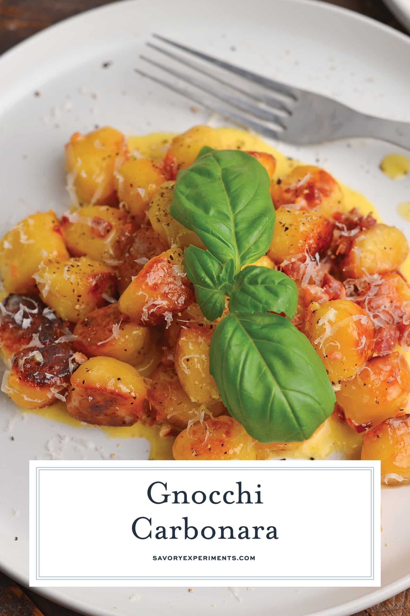 angled shot of gnocchi carbonara on a plate with text overlay for pinterest