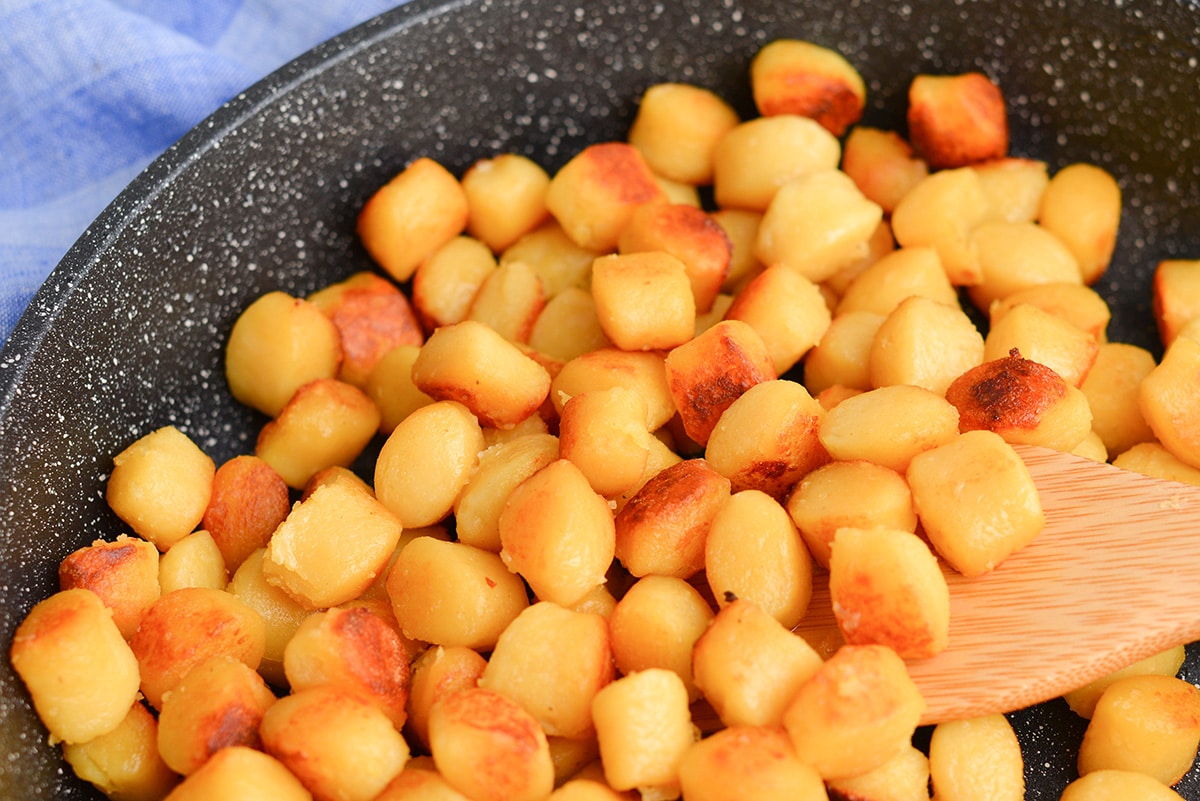 close up of browned gnocchi carbonara in a pan