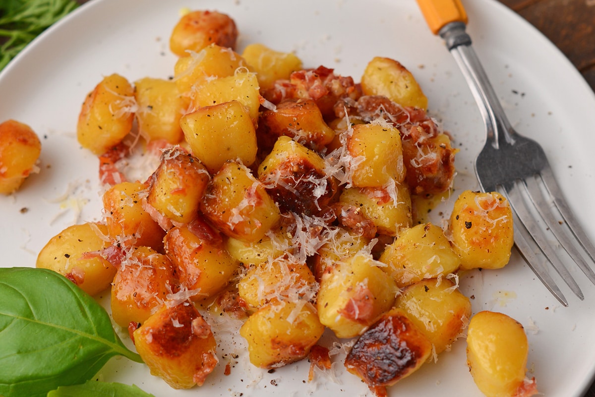 close up of gnocchi carbonara on a white plate