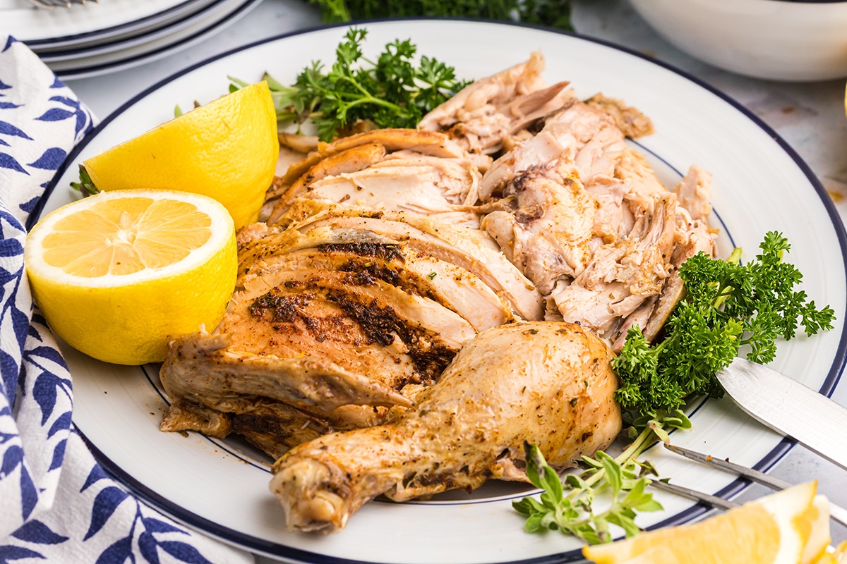 sliced chicken on a plate with lemons