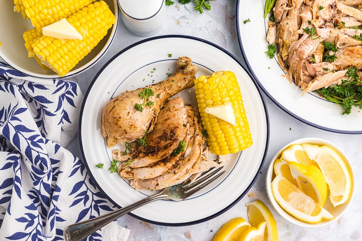 instant pot whole chicken sliced on a plate with corn