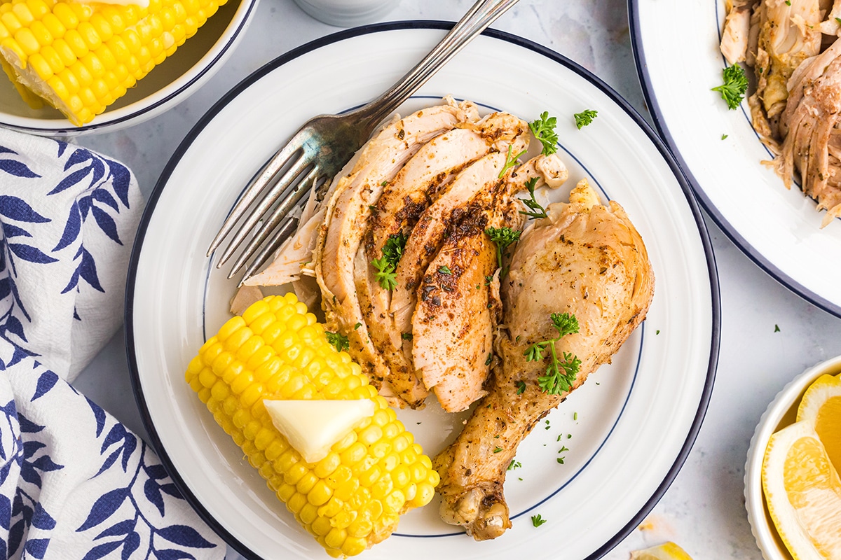 overhead shot of chicken on a plate with a fork and corn