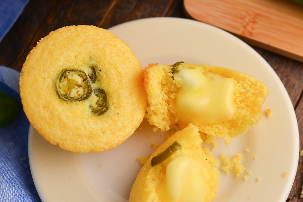 close up of butter on cut in half corn bread muffin