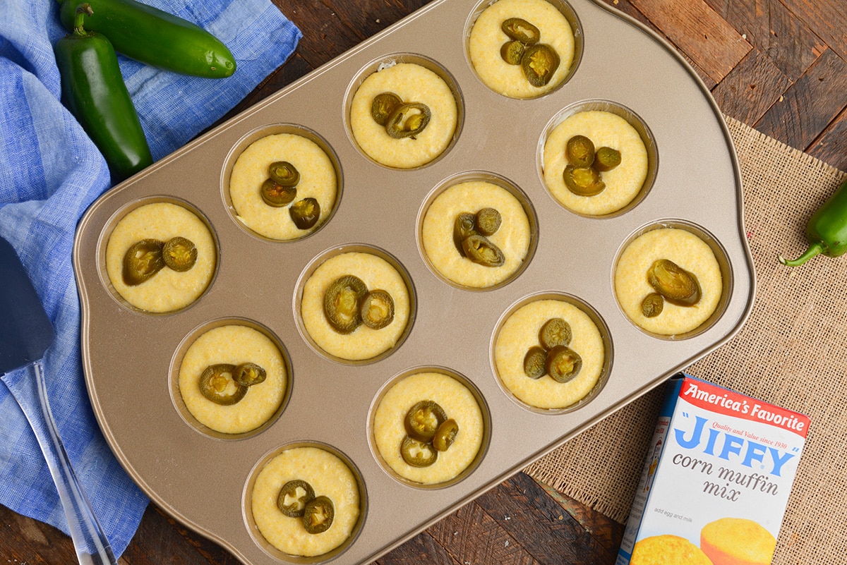 cornbread muffin batter in a tin topped with jalapenos