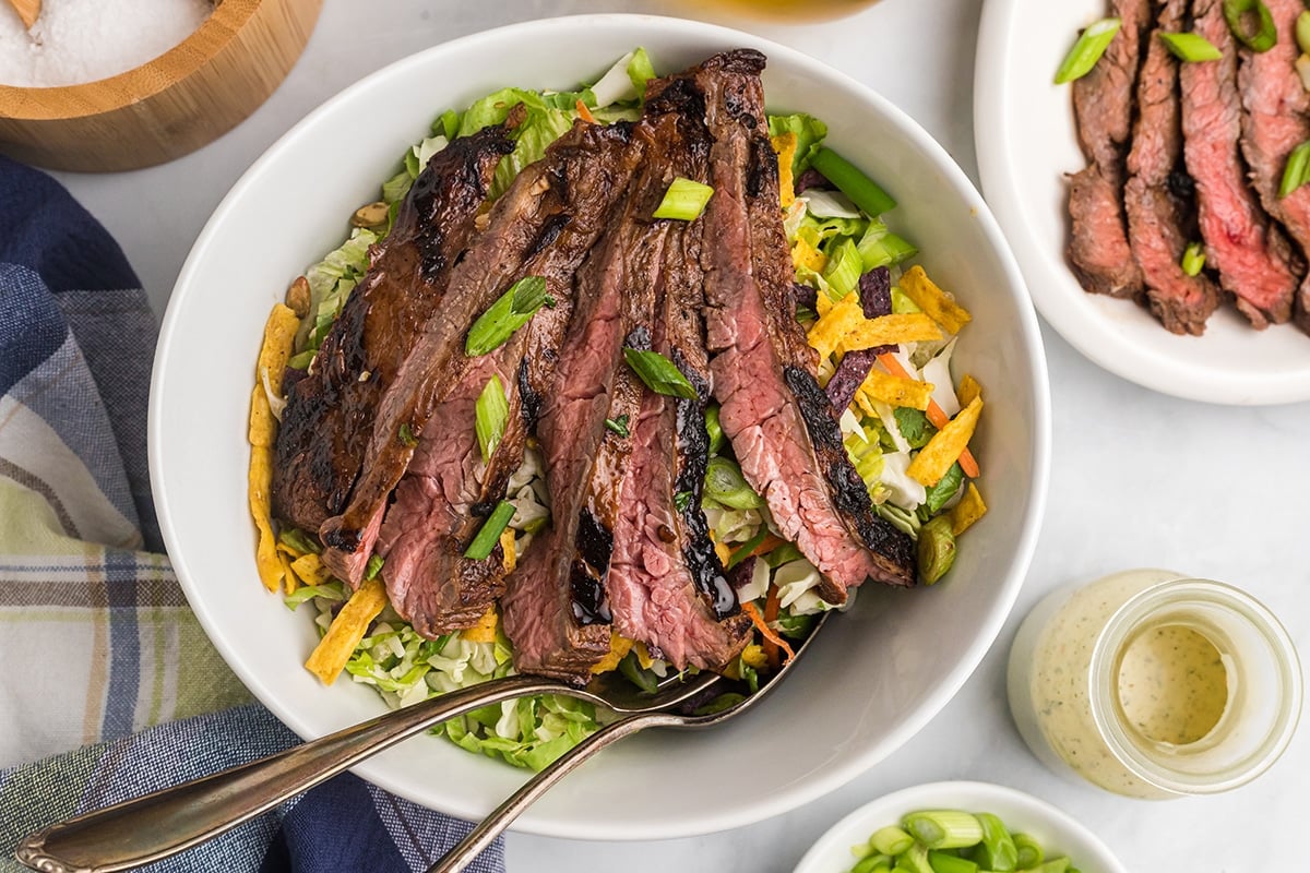 overhead shot of salad topped with skirt steak