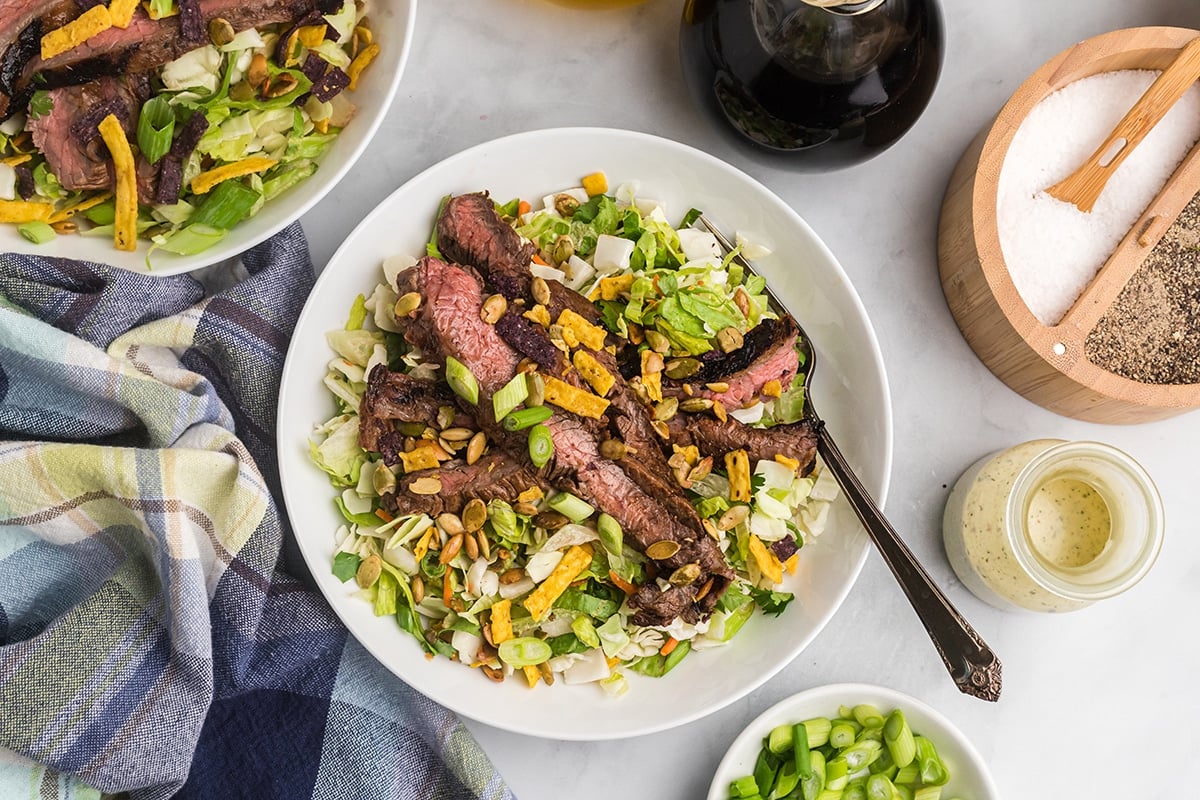 overhead shot of salad topped with sliced skirt steak