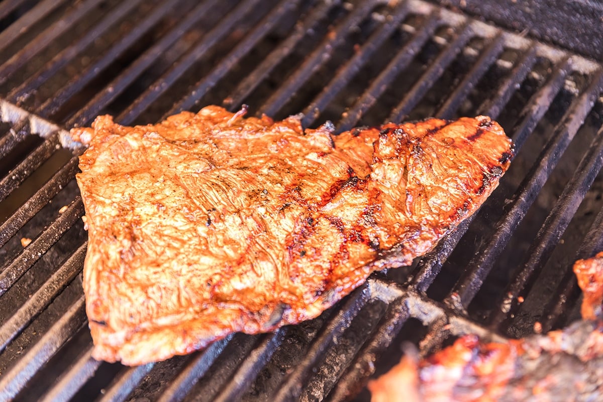 skirt steak cooking on grill