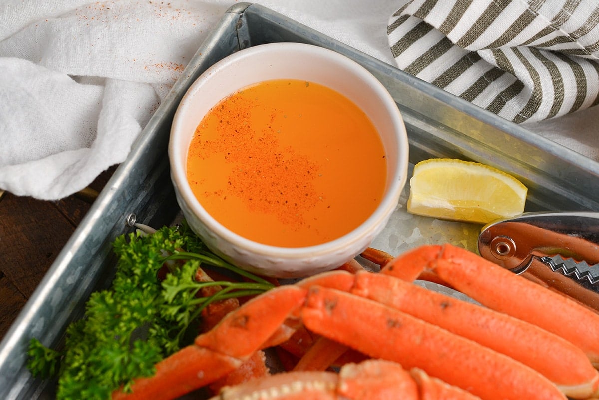 angled shot of drawn butter on tray of crab legs