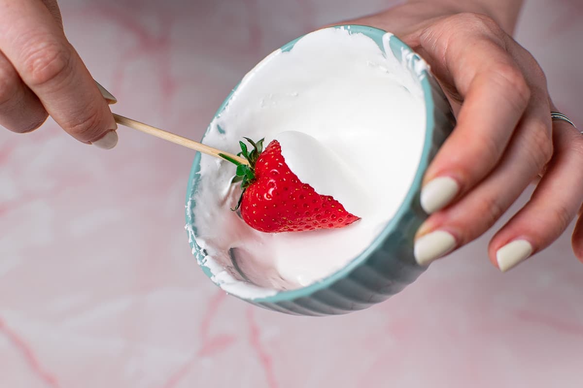 strawberry dipping into bowl of marshmallow fluff