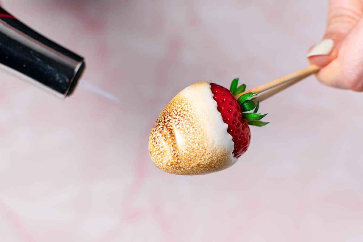 torch toasting marshmallow on strawberry