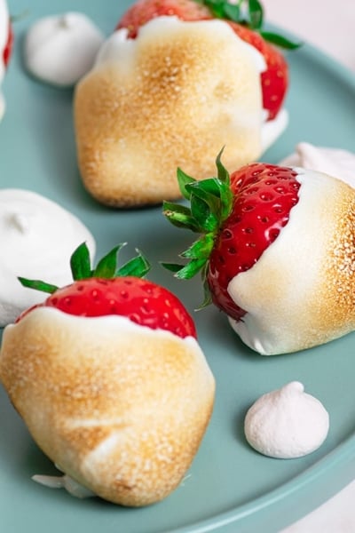 close up of toasted marshmallow strawberries on a plate