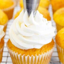 piping buttercream onto cupcake