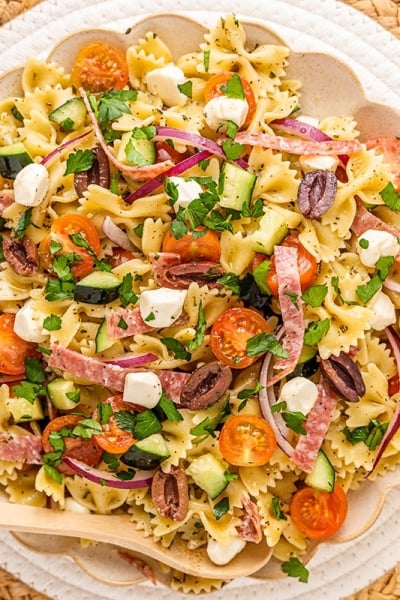 overhead shot of bowl of antipasto pasta salad with wooden spoon