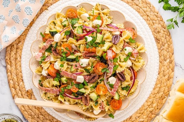 overhead shot of bowl of antipasto pasta salad with wooden spoon