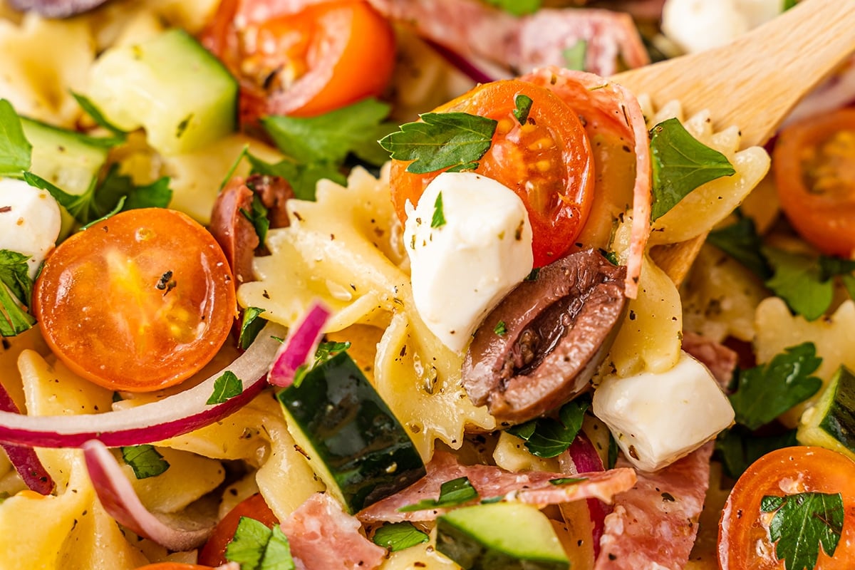 spoon digging into bowl of italian pasta salad