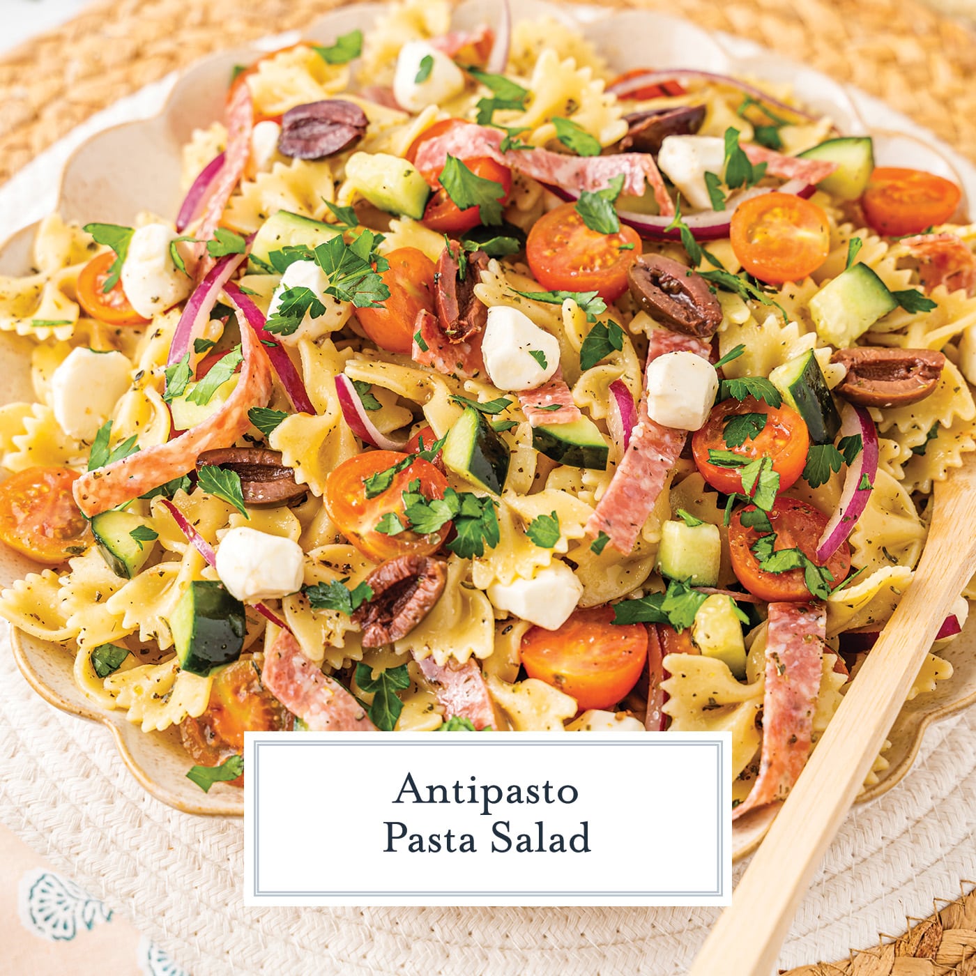 angled shot of bowl of antipasto pasta salad with text overlay for facebook