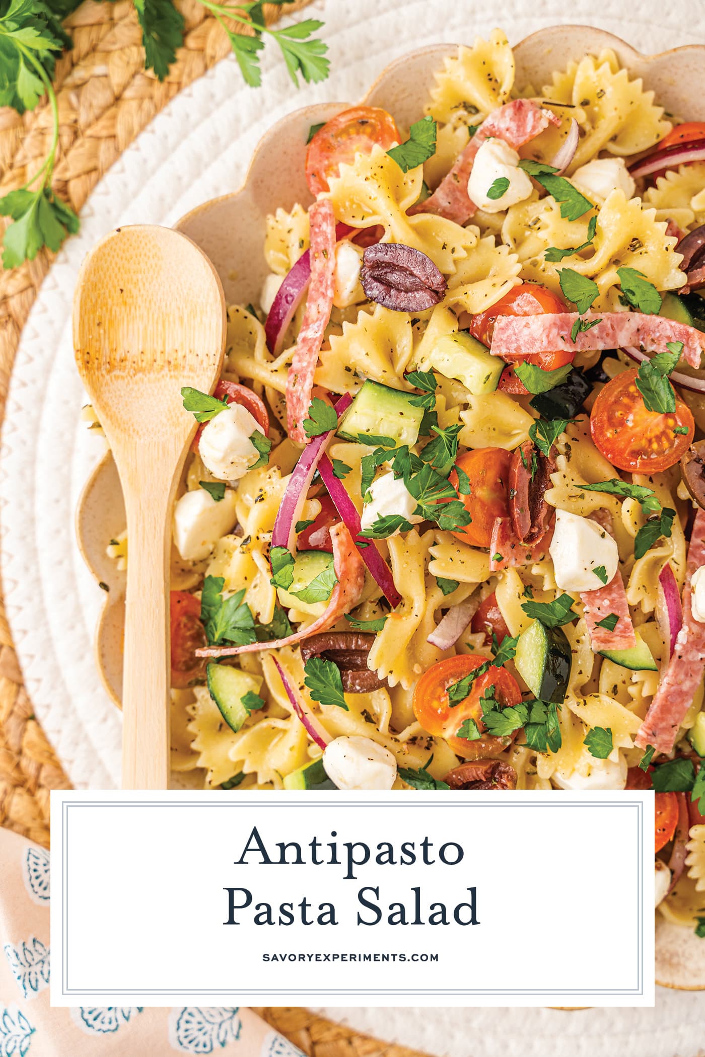 half overhead shot of antipasto pasta salad with text overlay for pinterest