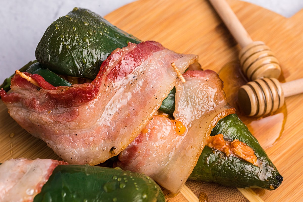 close up angled shot of bacon wrapped stuffed peppers