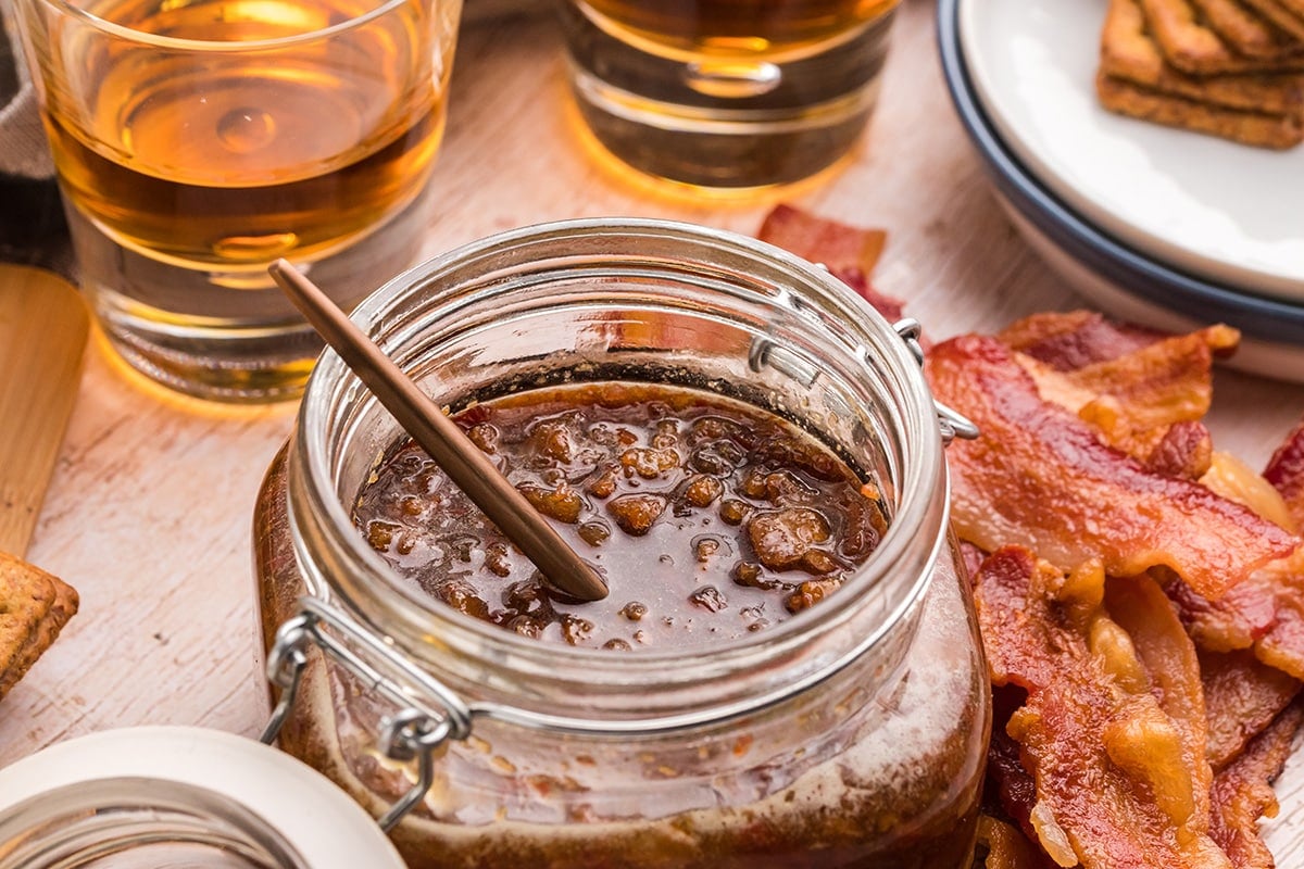 angled shot of spoon in jar of bourbon bacon jam