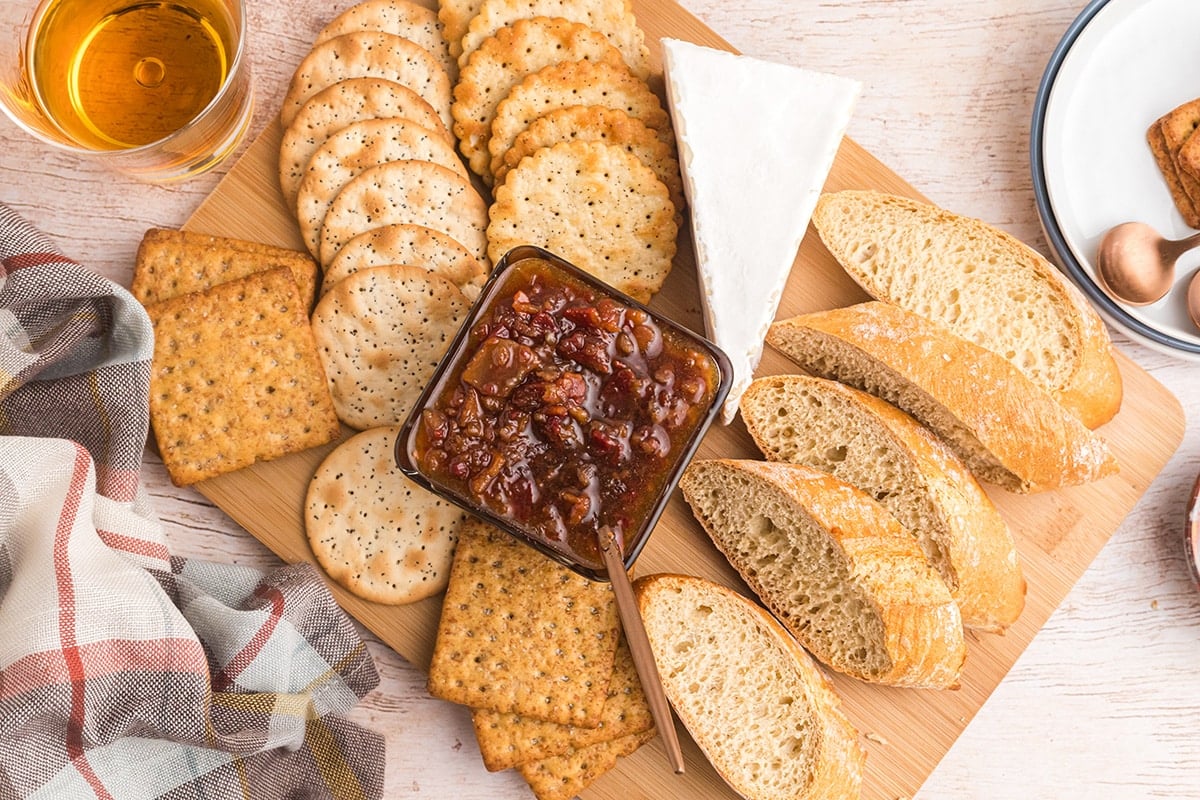 overhead shot of bowl of bacon jam on board with breads