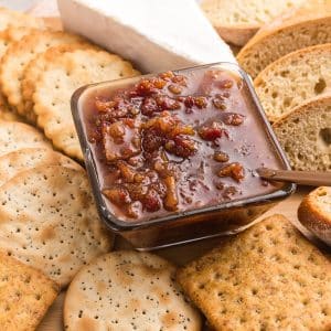 angled shot of bowl of bacon jam on board with breads