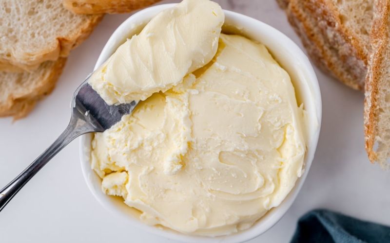 spreading knife in bowl of butter