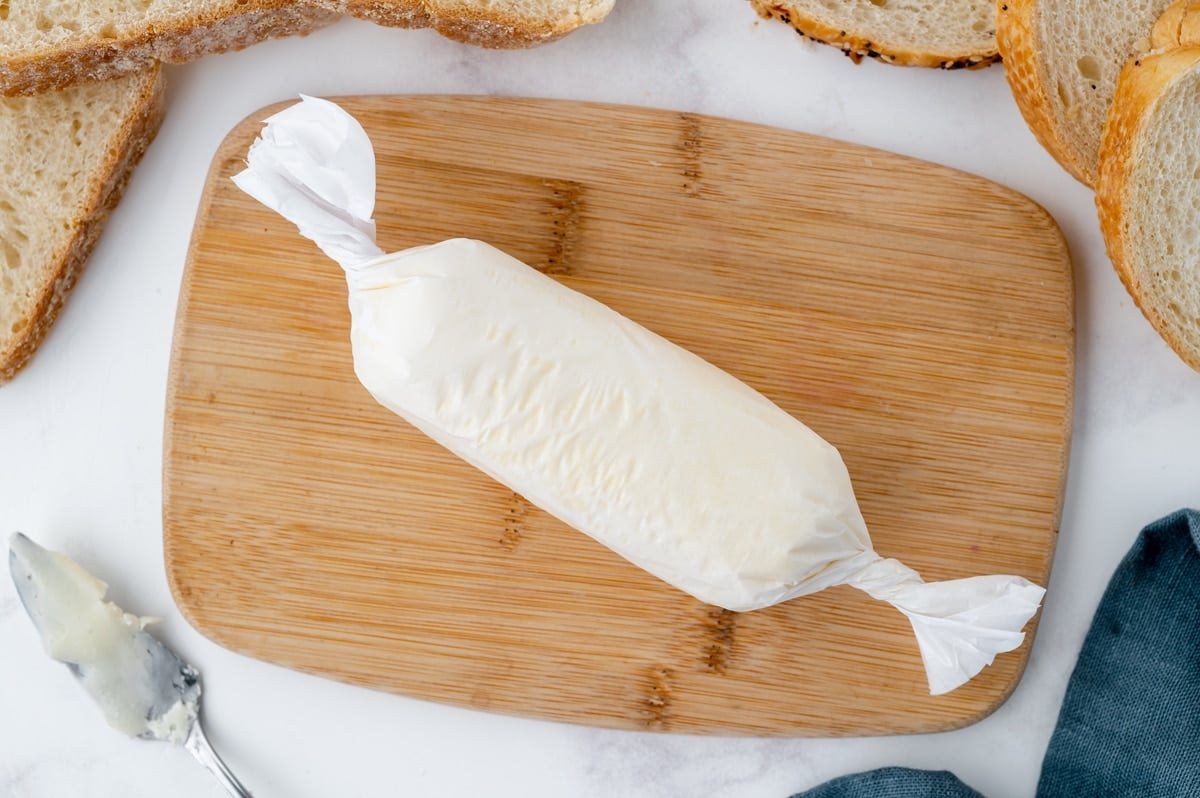 overhead shot of rolled butter on a cutting board