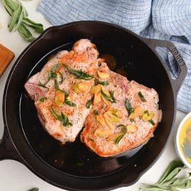overhead of pork chops in a butter sage sauce