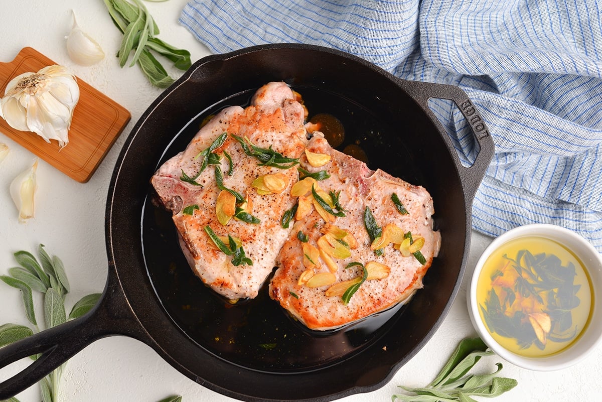 overhead of pork chops in a butter sage sauce