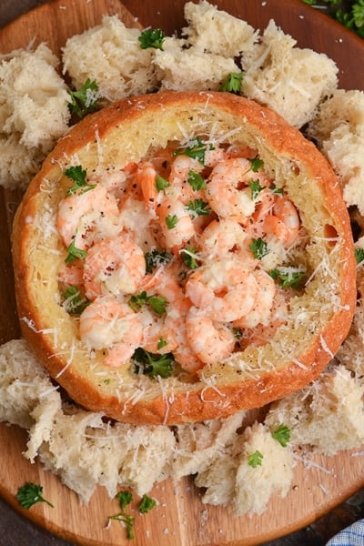 bread bowl filled with creamy shrimp scampi and topped with parmesan cheese and parsley